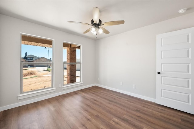 empty room with ceiling fan and dark hardwood / wood-style flooring