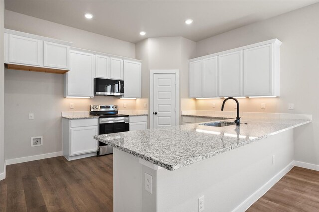 kitchen with white cabinetry, sink, stainless steel appliances, and kitchen peninsula