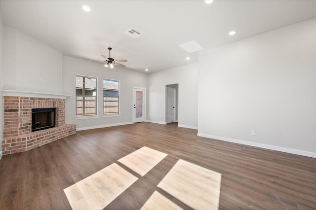 unfurnished living room with ceiling fan, dark hardwood / wood-style floors, and a fireplace