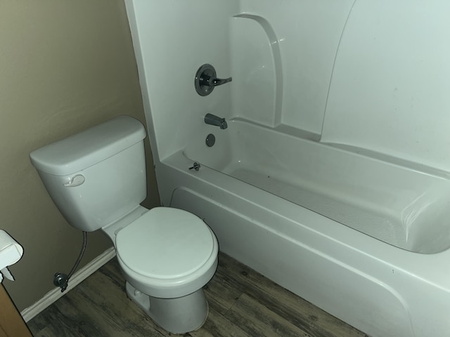 bathroom featuring wood-type flooring, toilet, and shower / washtub combination