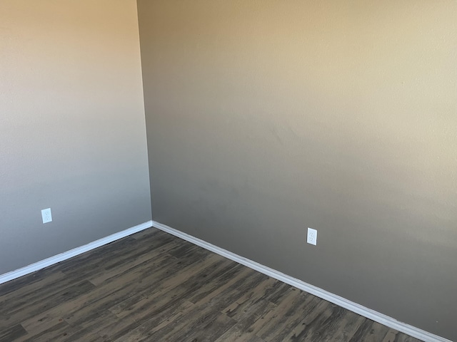 unfurnished room with dark wood-type flooring