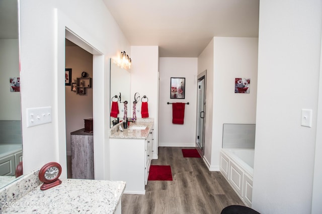 5719 117th St, Lubbock, TX 79424 - full bathroom featuring vanity, wood finished floors, a garden tub, and a shower with shower door