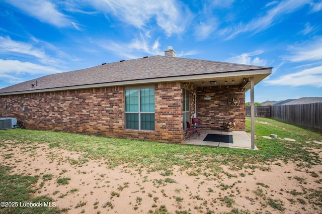 7023 35th St, Lubbock, TX 79407 - rear view of property featuring a chimney, brick siding, a patio, central air condition unit, and a fenced backyard
