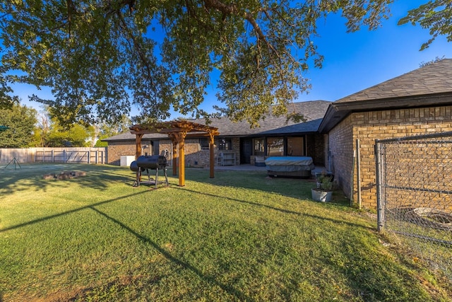 back of house with a pergola, a lawn, and a jacuzzi