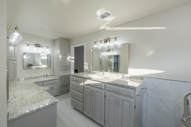 bathroom featuring vanity and tile walls