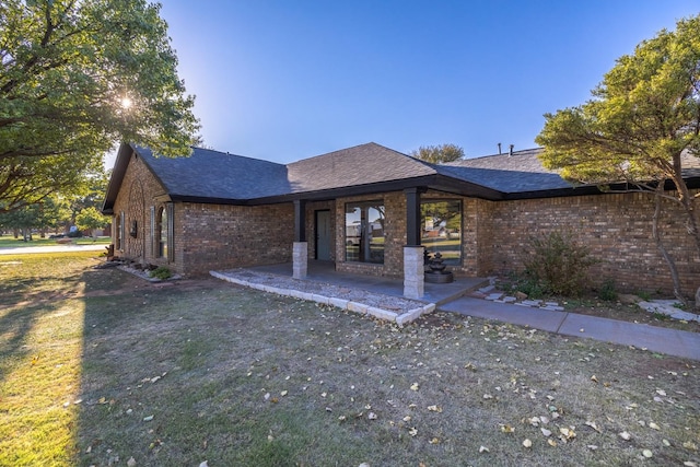 back of property with a patio area and a lawn