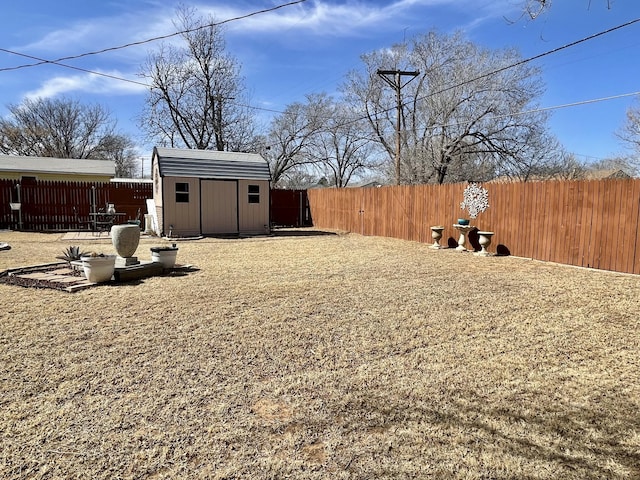 view of yard with a fenced backyard, an outdoor structure, and a shed