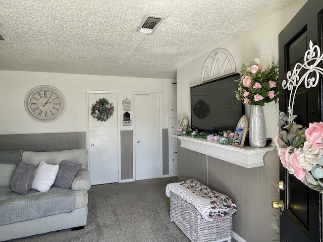 carpeted living room with a textured ceiling and visible vents