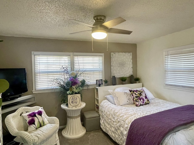 carpeted bedroom with a ceiling fan and a textured ceiling