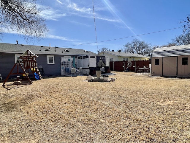 back of house with fence and a playground