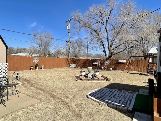 view of yard featuring a fenced backyard and a playground
