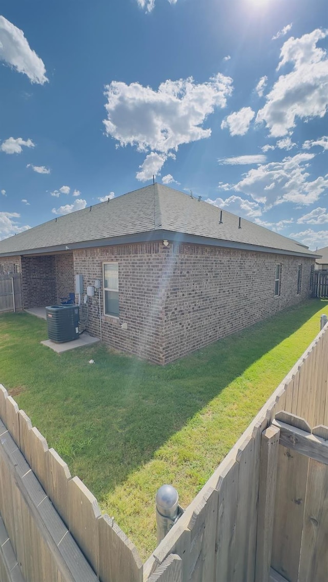 exterior space featuring central AC unit and a lawn