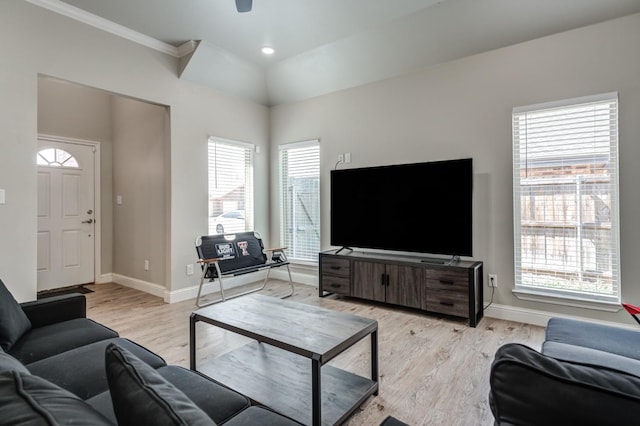 living room with lofted ceiling, crown molding, and light hardwood / wood-style floors