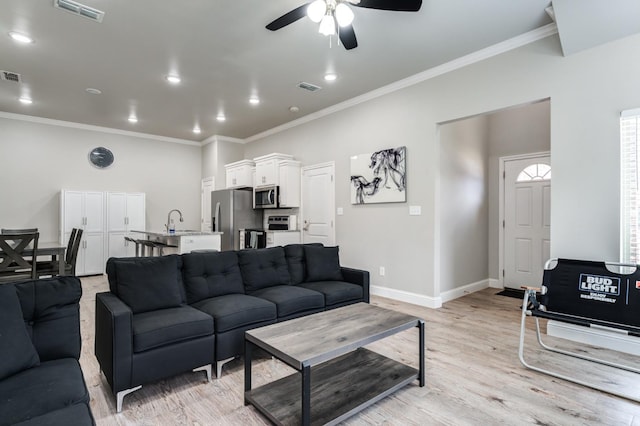 living room featuring ornamental molding, sink, ceiling fan, and light hardwood / wood-style flooring