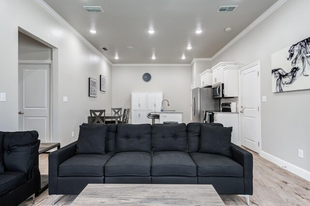 living room with crown molding and light hardwood / wood-style flooring