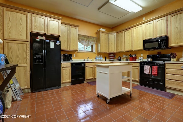 kitchen with light brown cabinets, dark tile floors, sink, and black appliances