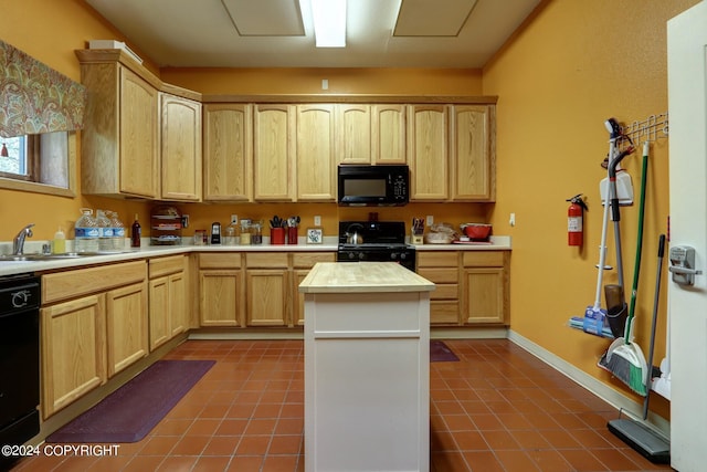 kitchen with dark tile floors, light brown cabinetry, a kitchen island, black appliances, and sink