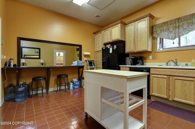 kitchen with light brown cabinets, sink, black appliances, and tile floors