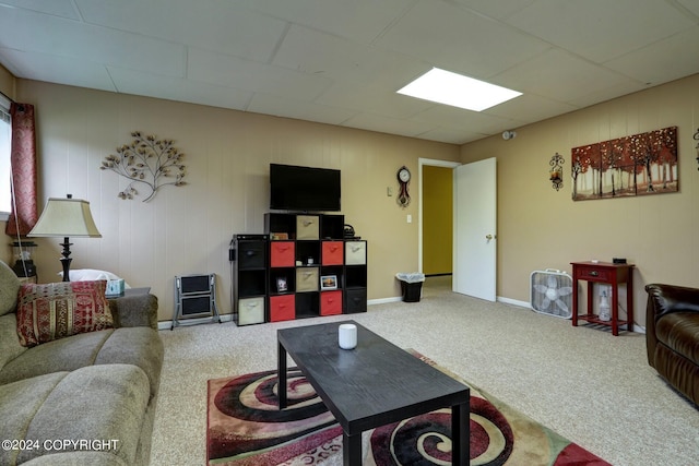 carpeted living room featuring a drop ceiling