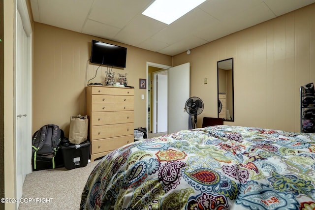 bedroom featuring carpet floors and a drop ceiling