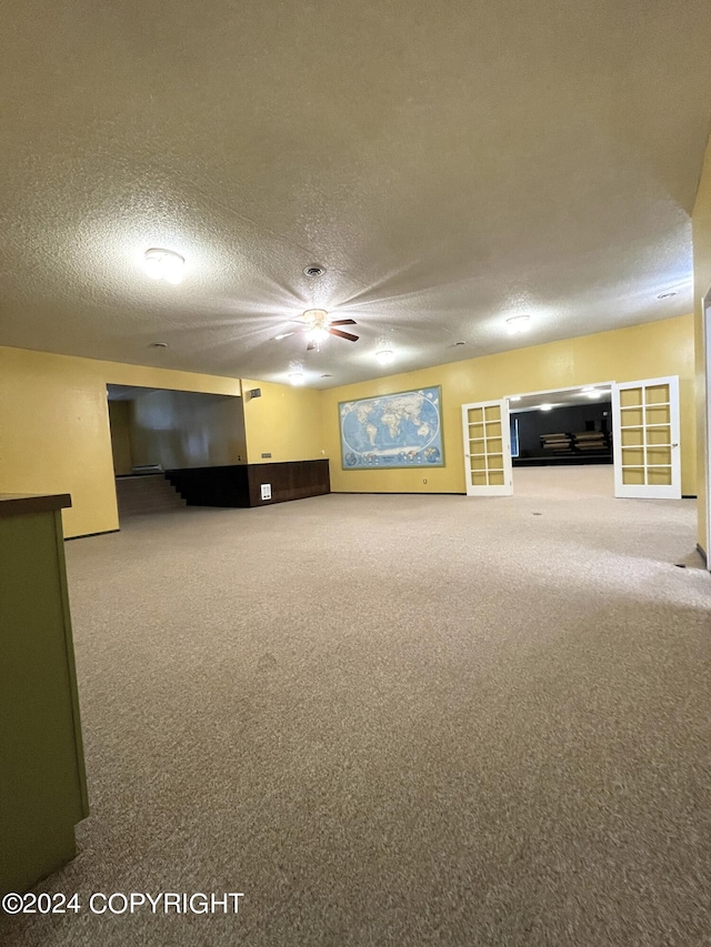 unfurnished living room with a textured ceiling and carpet floors