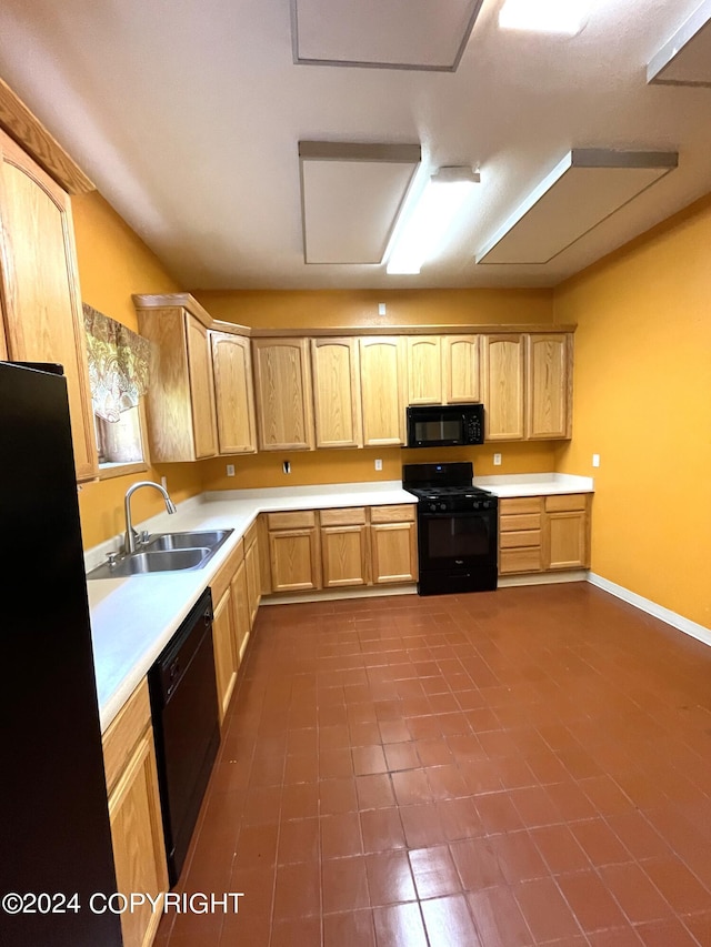 kitchen with sink, black appliances, dark tile floors, and light brown cabinetry