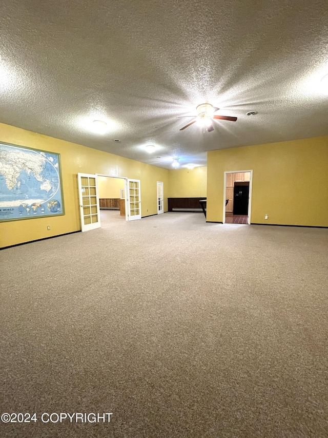 carpeted spare room featuring ceiling fan and a textured ceiling