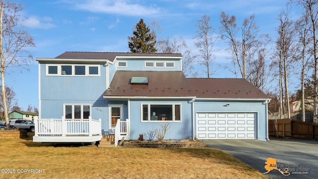 view of front of home featuring a front lawn, fence, a wooden deck, driveway, and an attached garage