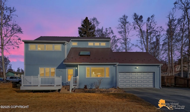 view of front of house featuring a deck, fence, a garage, and driveway