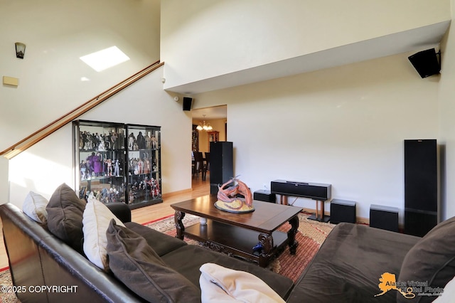 living room featuring a notable chandelier, a high ceiling, and wood finished floors