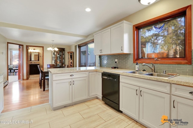 kitchen with tasteful backsplash, a peninsula, black dishwasher, and a sink