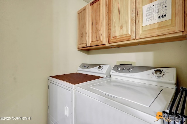 washroom featuring washer and clothes dryer and cabinet space