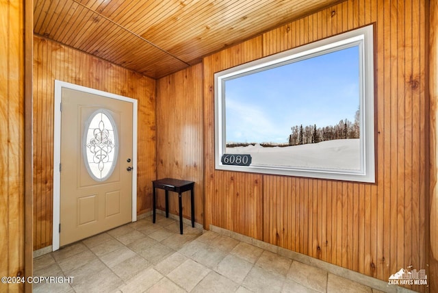 tiled entrance foyer with wooden walls and wooden ceiling