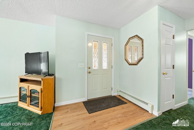 entryway with dark hardwood / wood-style flooring, a textured ceiling, and a baseboard heating unit