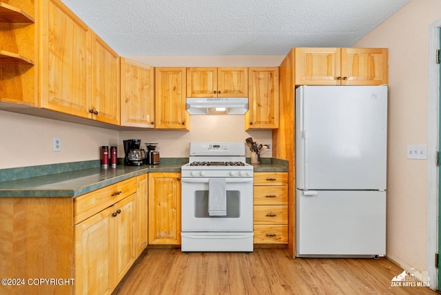 kitchen featuring white appliances, a textured ceiling, and light wood-type flooring