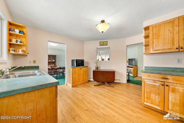 kitchen featuring light hardwood / wood-style floors, a baseboard radiator, a textured ceiling, and sink