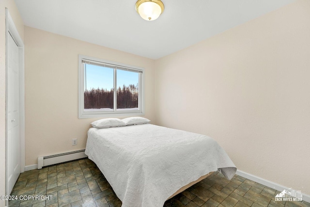 tiled bedroom with baseboard heating and a closet