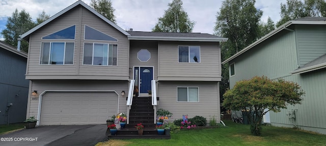 bi-level home with driveway, a garage, and a front yard