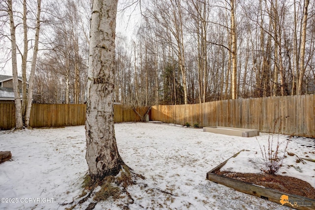 yard layered in snow featuring a fenced backyard