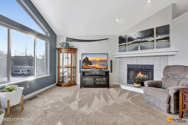 living room featuring carpet, a fireplace, visible vents, vaulted ceiling, and baseboards