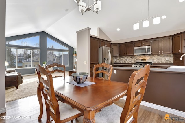 dining space featuring lofted ceiling, an inviting chandelier, baseboards, and dark wood-type flooring