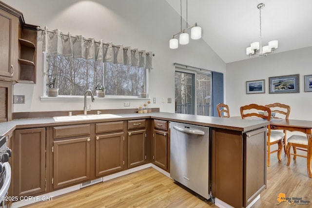 kitchen with a peninsula, a sink, hanging light fixtures, stainless steel dishwasher, and open shelves