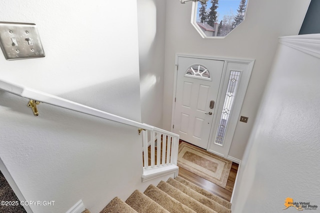 foyer entrance featuring stairs and wood finished floors