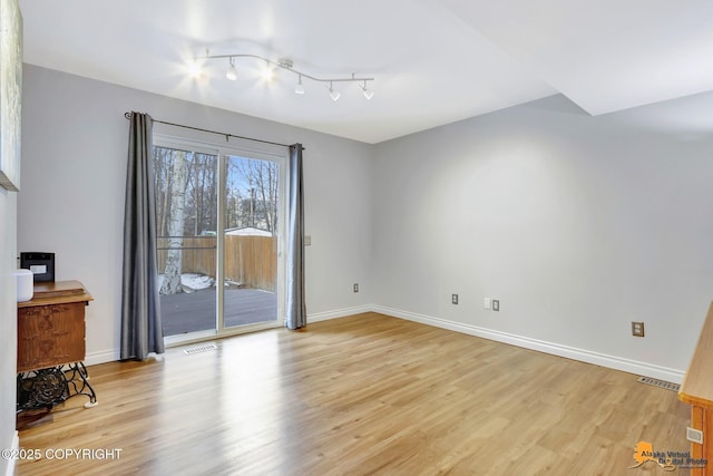 unfurnished room featuring light wood finished floors, baseboards, and visible vents