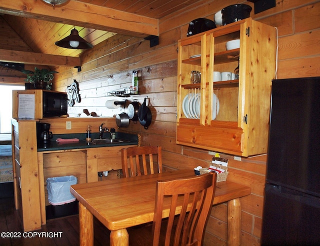 dining area featuring wooden walls, sink, beamed ceiling, and wooden ceiling