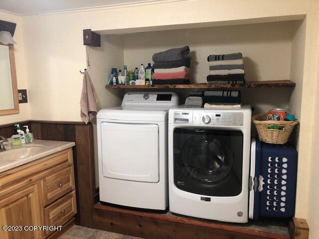 washroom with sink and washing machine and clothes dryer