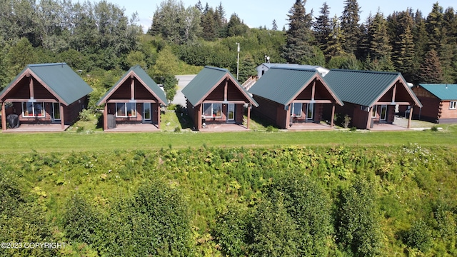 back of house featuring a lawn and an outbuilding