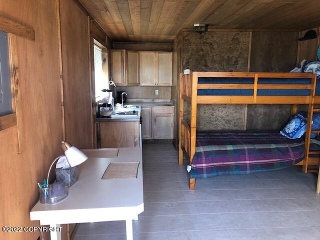 bedroom featuring wooden walls and wood ceiling