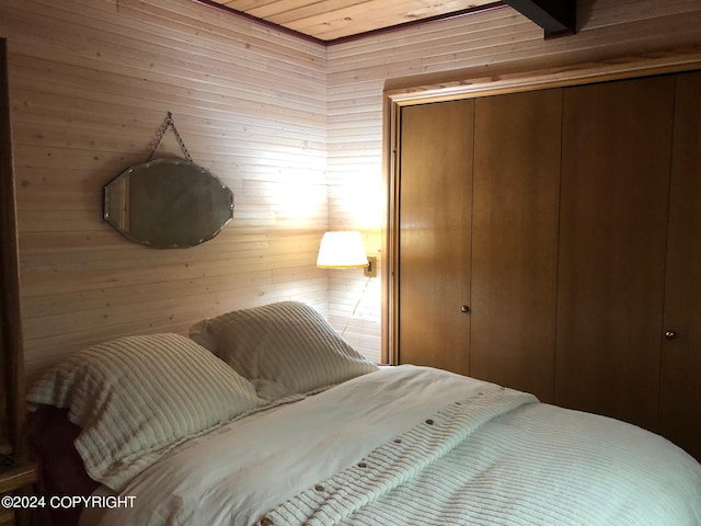 bedroom featuring wood ceiling and wooden walls