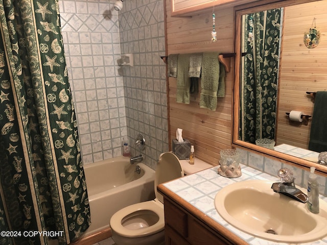 full bathroom with vanity, toilet, shower / tub combo with curtain, and wood walls